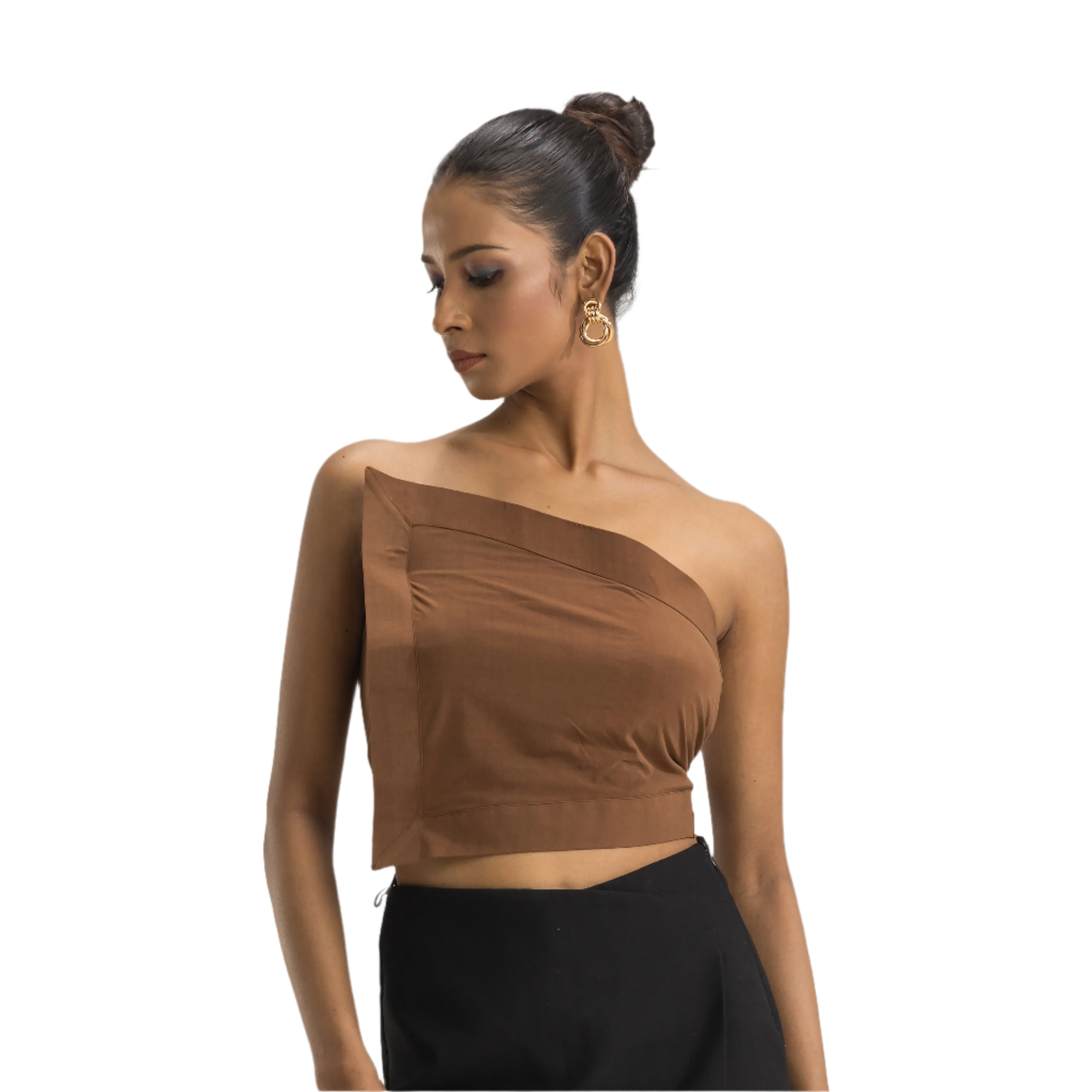 A woman wearing a brown asymmetrical flap crop top with a V-neckline and sleeveless design, paired with black pants.